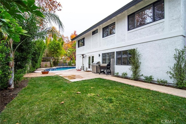 back of property featuring a yard and a patio