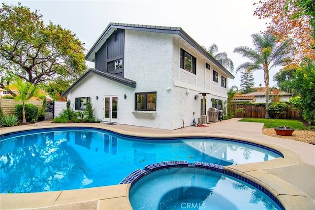 view of swimming pool featuring an in ground hot tub and a patio area