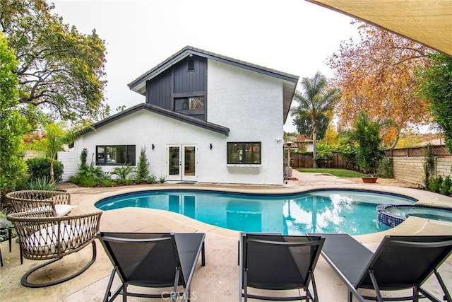 view of pool featuring french doors, an in ground hot tub, and a patio