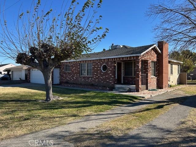 single story home featuring a garage and a front yard