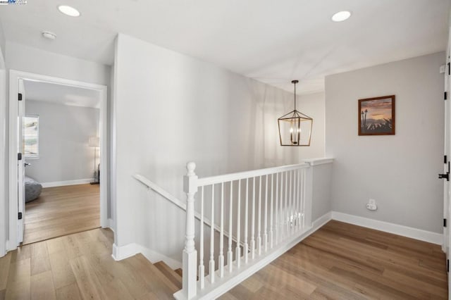 corridor featuring light hardwood / wood-style flooring and a chandelier