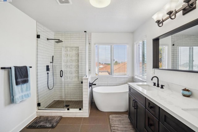 bathroom featuring shower with separate bathtub, tile patterned floors, and vanity