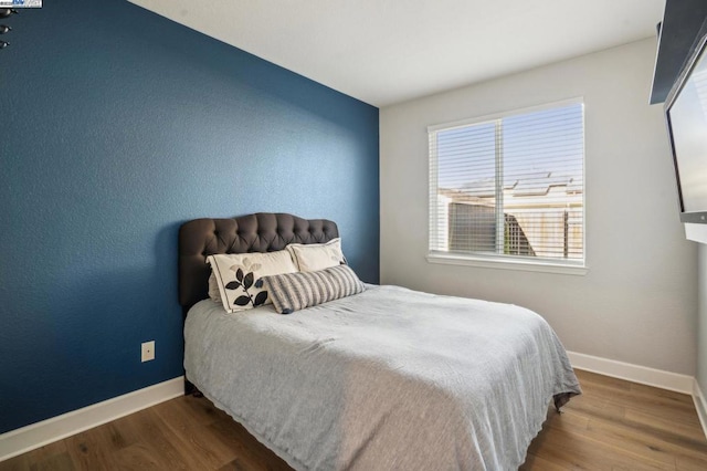 bedroom with dark wood-type flooring