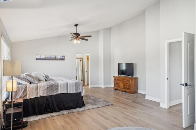 bedroom featuring ceiling fan, light hardwood / wood-style flooring, and lofted ceiling