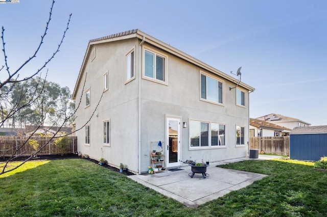 back of house featuring a lawn, a shed, cooling unit, and a patio