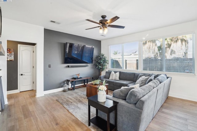 living room with ceiling fan, a wealth of natural light, and light hardwood / wood-style floors