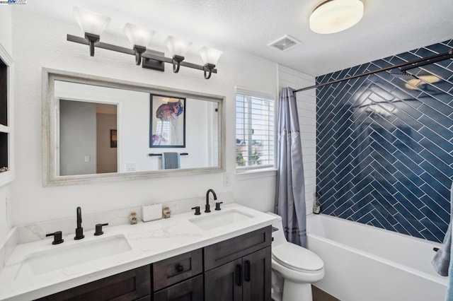 full bathroom featuring toilet, a textured ceiling, vanity, and shower / bath combo with shower curtain