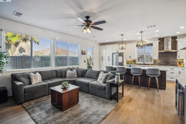 living room with ceiling fan and light wood-type flooring