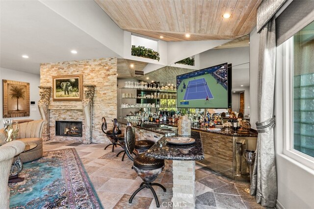 interior space with wood ceiling and a stone fireplace