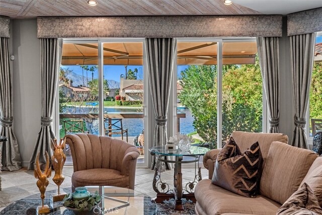 living area with wooden ceiling and a water view