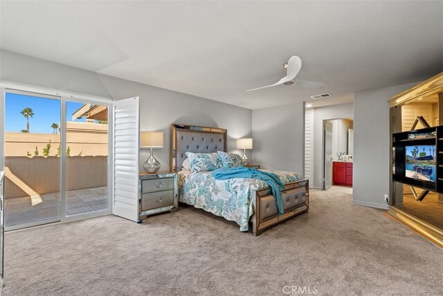 carpeted bedroom featuring ceiling fan, ensuite bath, and access to outside