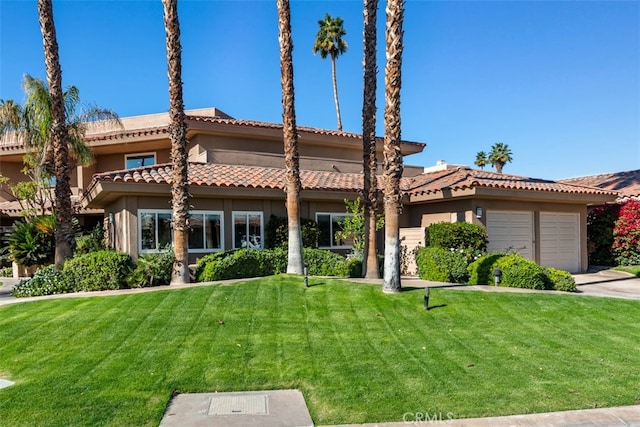 mediterranean / spanish house featuring a front yard and a garage