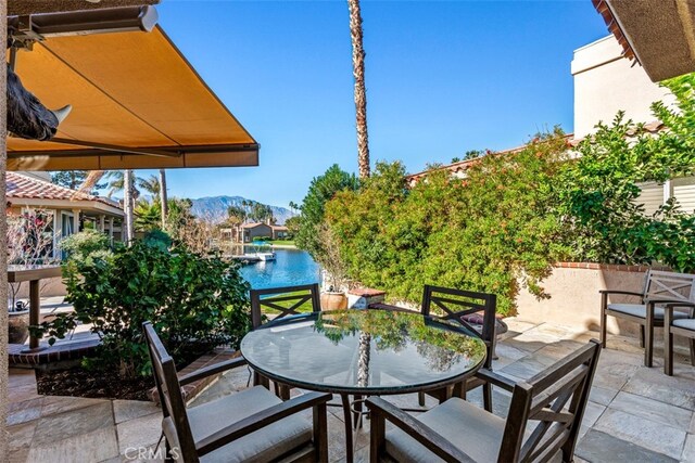 view of patio with a water and mountain view