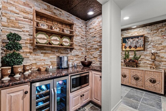 bar with dark stone counters and wine cooler