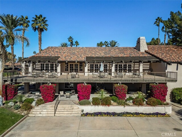 view of front of house with a wooden deck and a patio