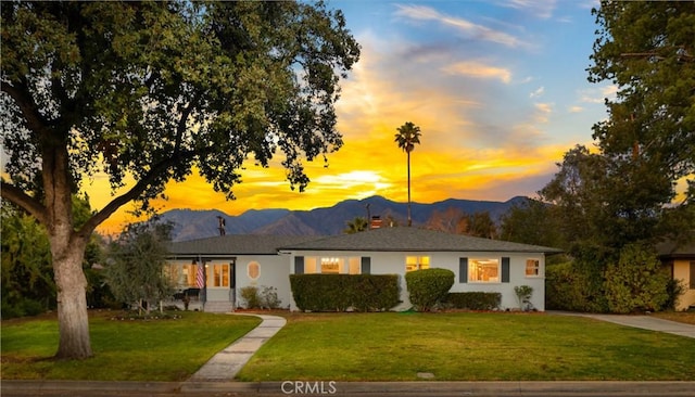 single story home featuring a mountain view and a lawn