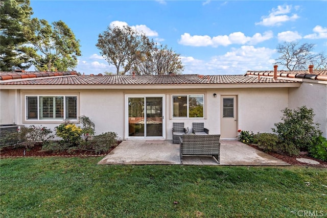 back of house with a lawn and a patio