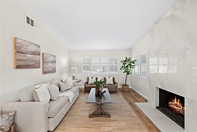 living room with light wood-type flooring and a fireplace