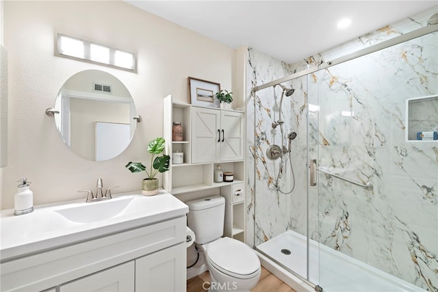 bathroom with an enclosed shower, vanity, and toilet