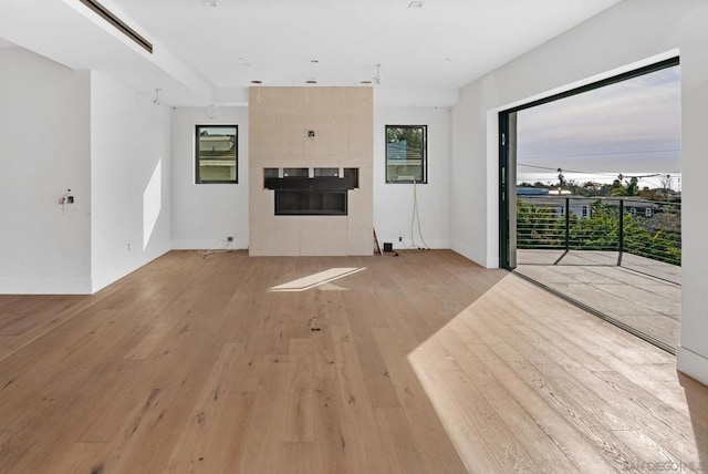 unfurnished living room with a fireplace and light hardwood / wood-style floors