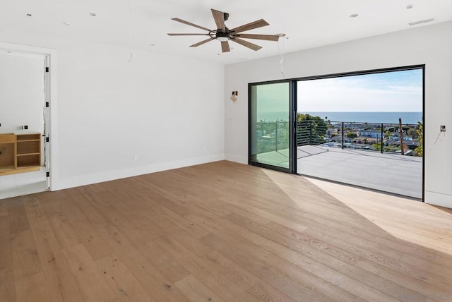 unfurnished room featuring a water view, ceiling fan, and light hardwood / wood-style flooring