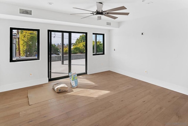 spare room with ceiling fan, a healthy amount of sunlight, and light wood-type flooring