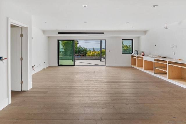 unfurnished living room featuring a healthy amount of sunlight and light wood-type flooring