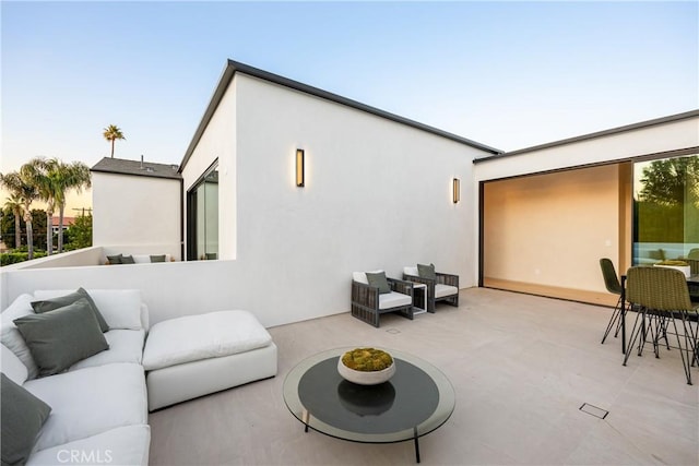 back house at dusk featuring an outdoor hangout area