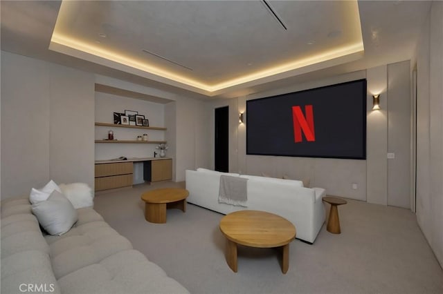 cinema room with carpet flooring and a tray ceiling