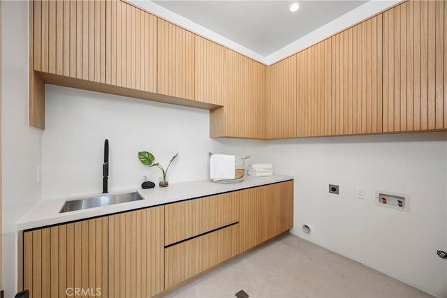 clothes washing area featuring hookup for an electric dryer, hookup for a washing machine, and sink