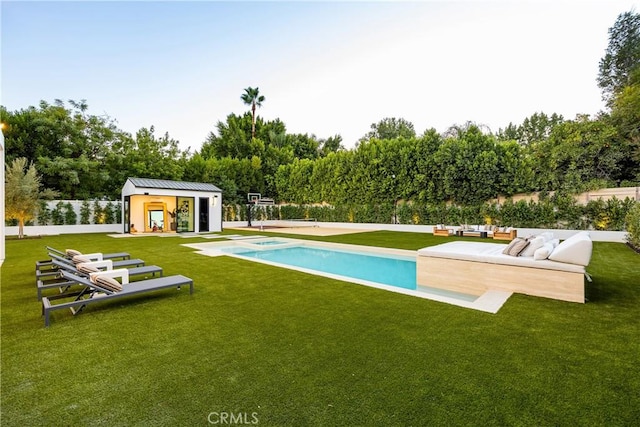 view of pool with a patio area, a lawn, and an outdoor structure