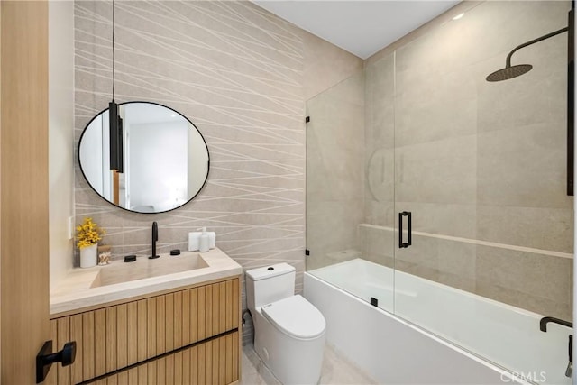 full bathroom featuring tasteful backsplash, vanity, tile walls, toilet, and enclosed tub / shower combo