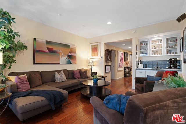 living room with dark hardwood / wood-style flooring, bar, and ornamental molding