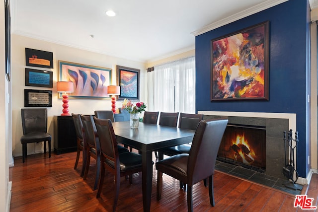 dining room with a tiled fireplace, dark hardwood / wood-style floors, and crown molding