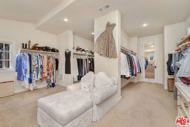 walk in closet featuring light carpet and radiator heating unit