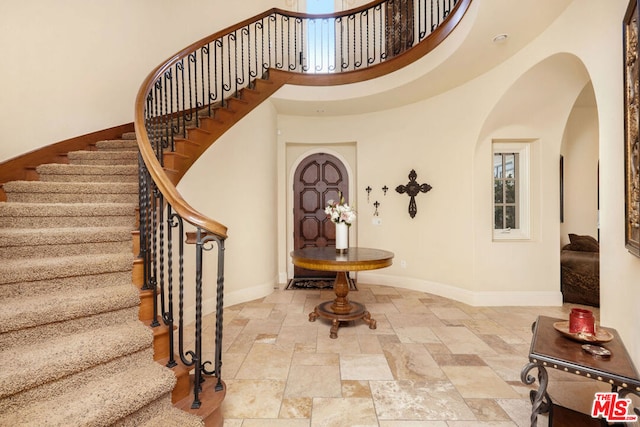 foyer entrance featuring a towering ceiling