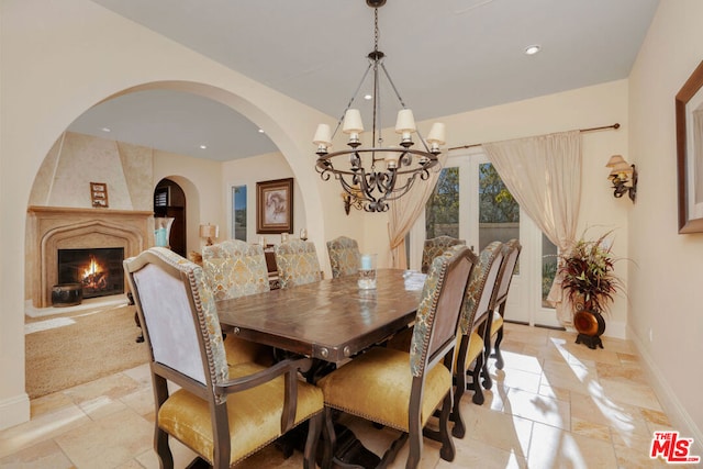 dining room featuring a chandelier and a fireplace