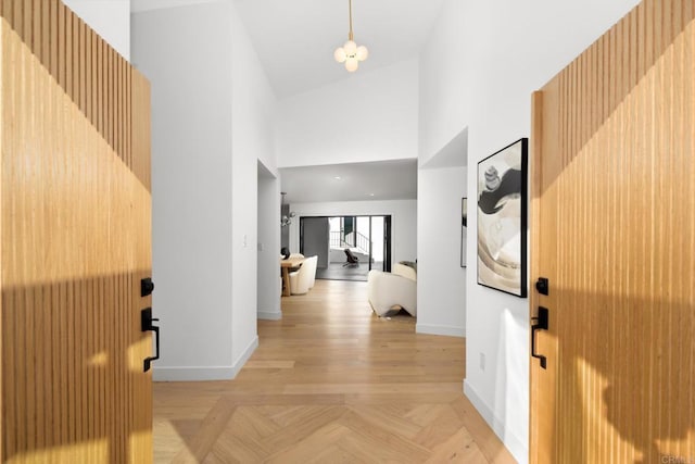 corridor featuring high vaulted ceiling and light parquet floors