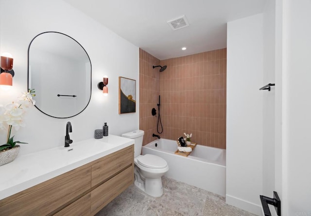 full bathroom featuring vanity, tiled shower / bath combo, and toilet