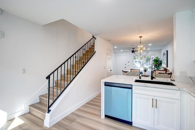 kitchen featuring white cabinets, dishwasher, decorative light fixtures, sink, and light wood-type flooring