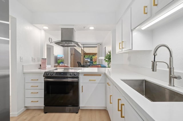 kitchen with sink, electric stove, white cabinets, and island range hood