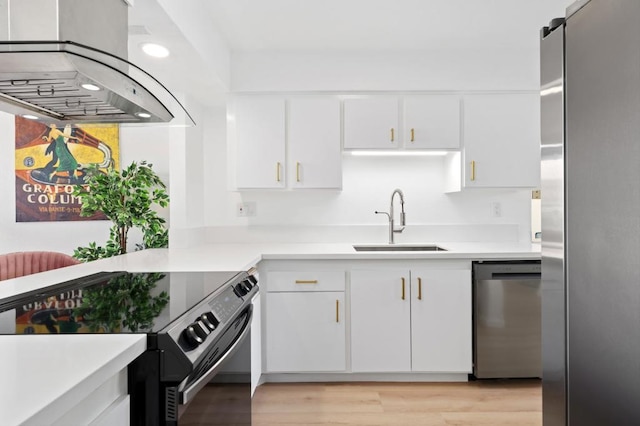 kitchen featuring island exhaust hood, sink, light wood-type flooring, appliances with stainless steel finishes, and white cabinets