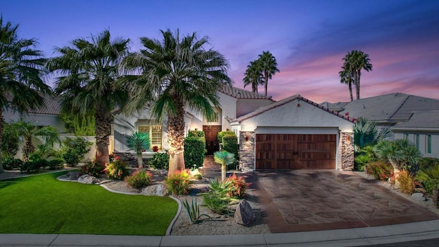 view of front of house with a garage and a yard