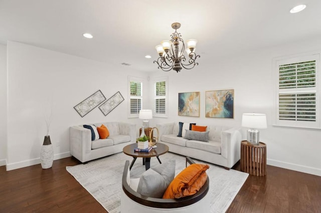 living room featuring dark wood-type flooring and a notable chandelier