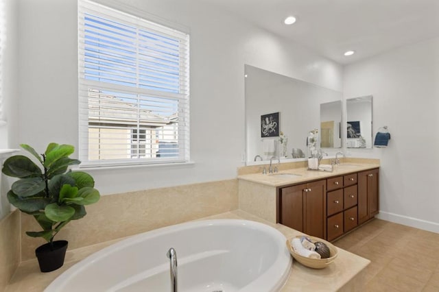 bathroom featuring vanity, a healthy amount of sunlight, a tub to relax in, and tile patterned flooring