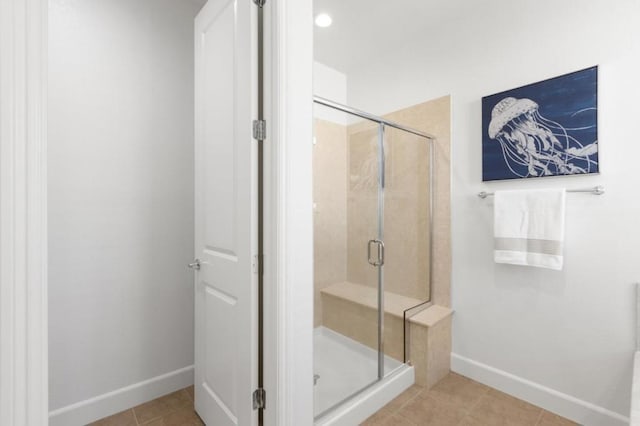 bathroom with a shower with shower door and tile patterned flooring