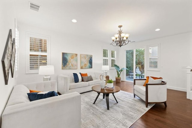 living room featuring wood-type flooring and a notable chandelier