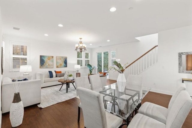 dining space with dark wood-type flooring and an inviting chandelier