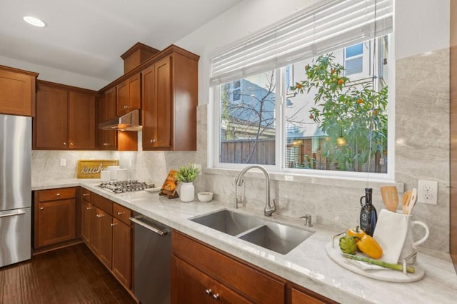 kitchen with sink, stainless steel appliances, light stone countertops, and tasteful backsplash