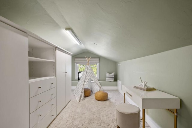 bedroom featuring light colored carpet and vaulted ceiling